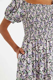 Louche London BABETTE Lilac Printed Rouched Bodice Dress. Babette is our dreamy throw on midi dress with flattering square neck line, easy fit smocked bodice perfect for those summery days. Features include elasticated cuffed puff sleeves and those essential side seam pockets. Can be worn on or off the shoulders.