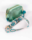 Lottie&Moll Ladies Teal Metallic Camera Handbag. A lovely little ladies crossbody handbag in a teal metallic finish. This bag comes with a matching integral strap that can be removed to add a more decorative strap of choice. There is an inner zip pocket and the metalwork and zip are gold.